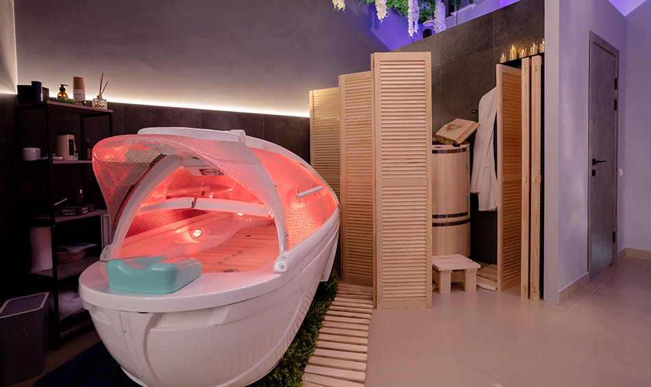 Red light therapy pod in modern spa room, highlighting advanced wellness and skin rejuvenation treatment space.