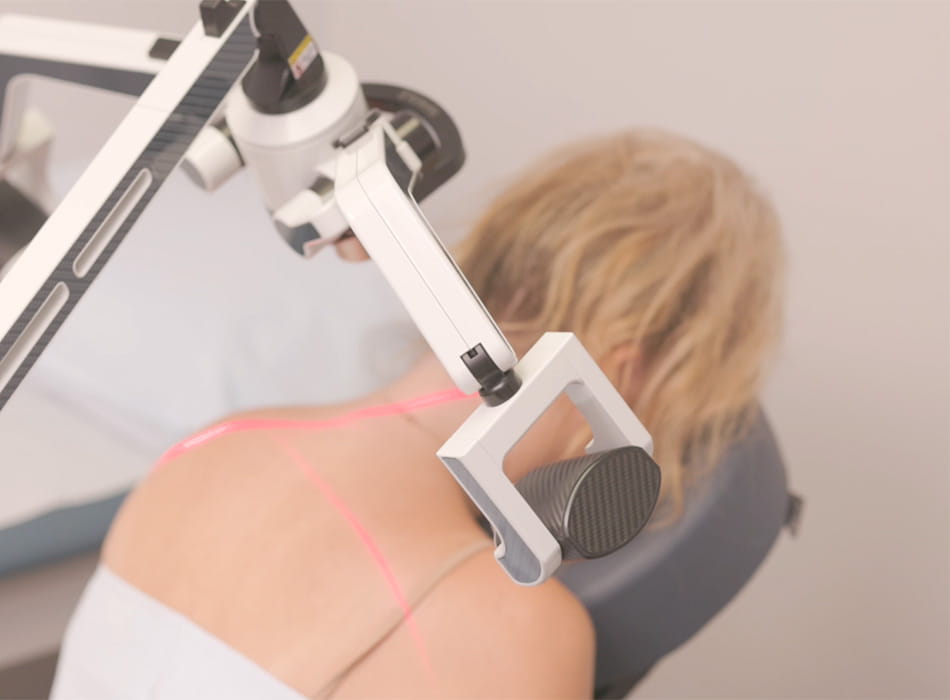 Erchonia Laser for shoulder pain Laser device targeting upper back with red guide beams, highlighting noninvasive pain relief treatment.