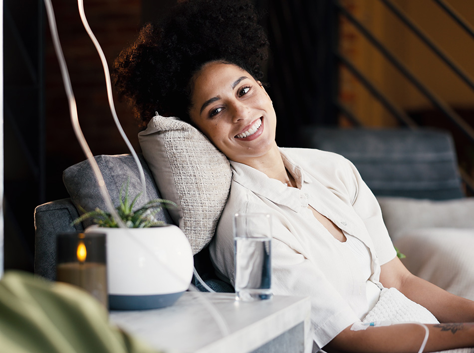 Smiling woman relaxing during IV therapy session, highlighting comfortable wellness treatment setting.